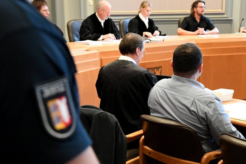 Der 41-Järhige sitzt neben seinem Anwalt im Kieler Landgericht.