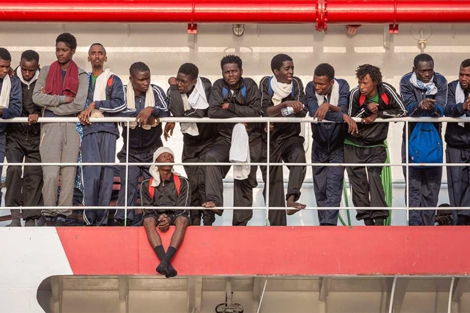 Flüchtlinge stehen am 14. Juli in Salerno (Italien) an Bord eines Rettungsschiffs der NGO "Ärzte ohne Grenzen". Das Schiff ist mit mehr als 900 Flüchtlingen an Bord im Hafen von Salerno eingelaufen.