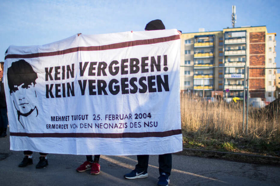 Linke Demonstranten halten am Rande der Gedenkstunde am Todestag des NSU-Opfers Mehmet Turgut am Tatort ein Transparent mit der Aufschrift "Kein Vergeben! Kein Vergessen".