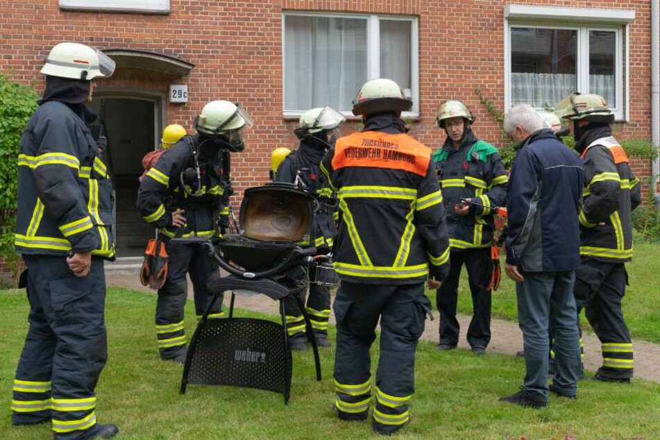 Einsatzkräfte bringen den defekten Gasgrill ins Freie.