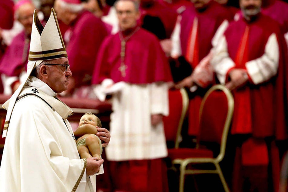 Während der Messe hält der Pontifex eine Jesusfigur in der Hand.