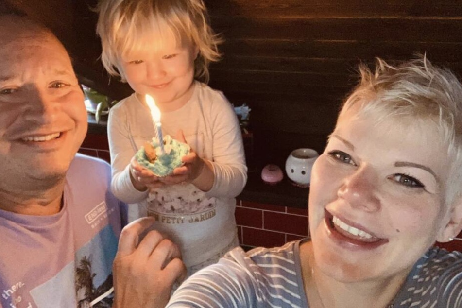 Voller Begeisterung hält die kleine Mia Rose an ihrem 2. Geburtstag ein Krümelmonster-Muffin mit brennenden Kerzen in der Hand.