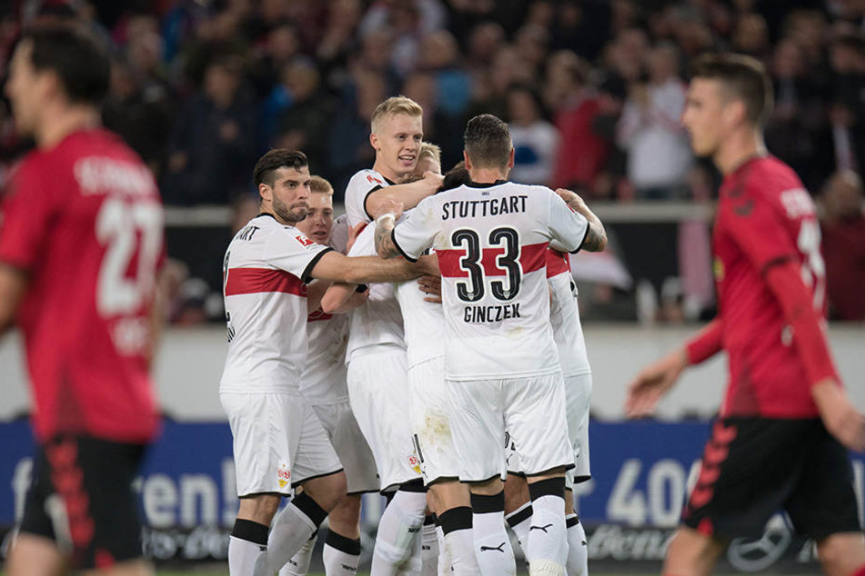 Die VFB-Kicker bejubeln einen von drei Treffern. Die Freiburger Spieler schleichen bedrückt zum Anstoßpunkt.