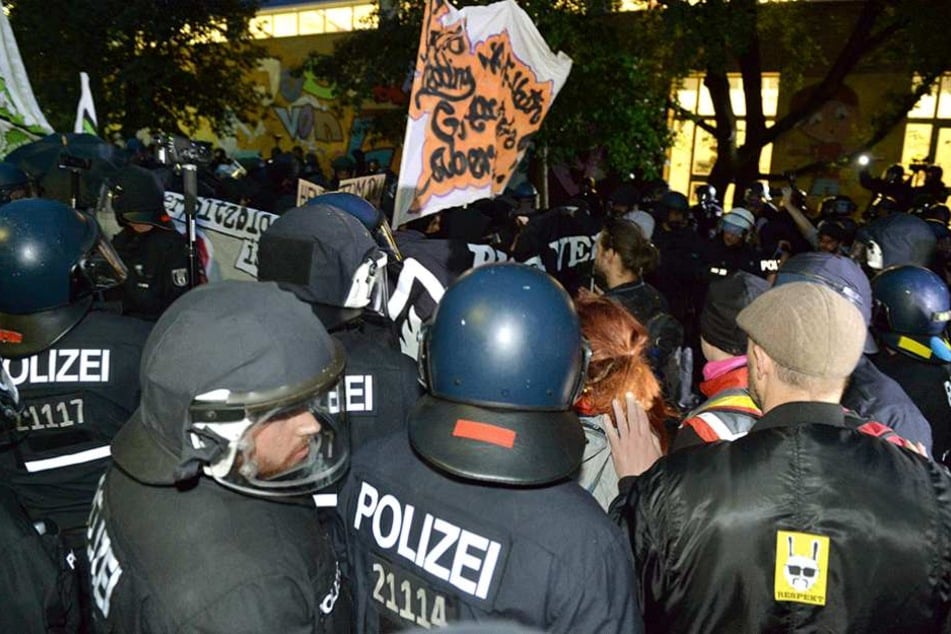 Polizisten stehen vor einem besetzten Haus auf der Rigaer Straße, wo linksautonome immer wieder Krawalle machen.