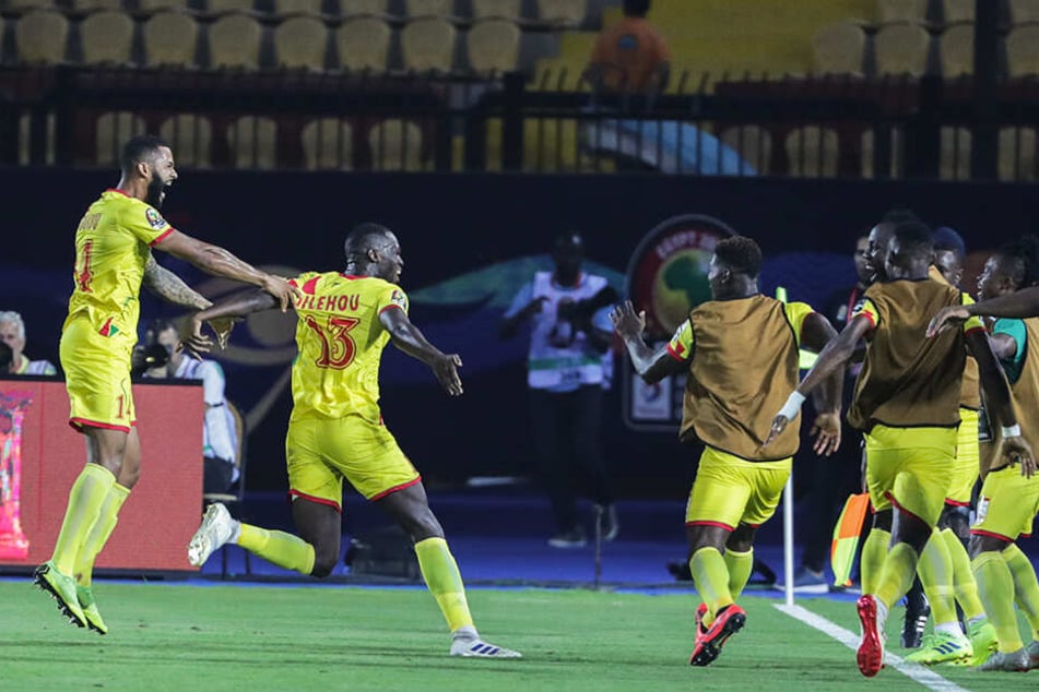 Cebio Soukou (l.) bejubelt mit seinen Mannschaftskollegen die zwischenzeitliche 1:0-Führung des Benin.