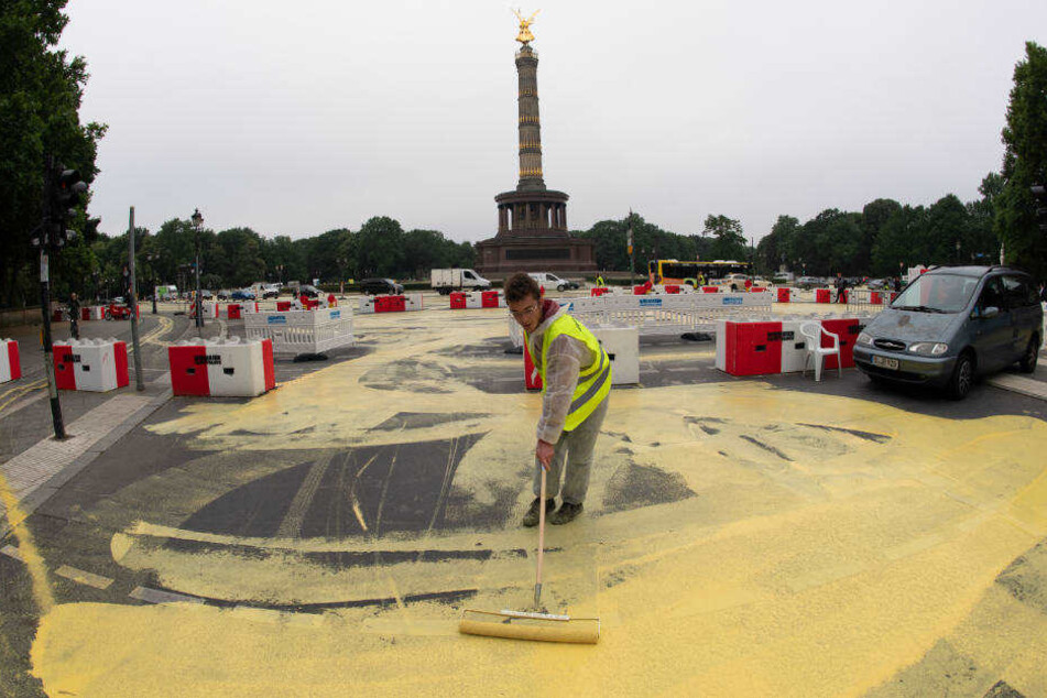 Aktivisten tragen die abwaschbare Öko-Farbe mit Rollen auf.