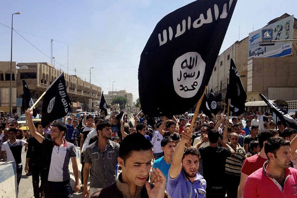 Irakische Unterstützer des Islamischen Staats demonstrieren und schwenken Flaggen des IS vor dem Hauptsitz der Regierung in Mosul.