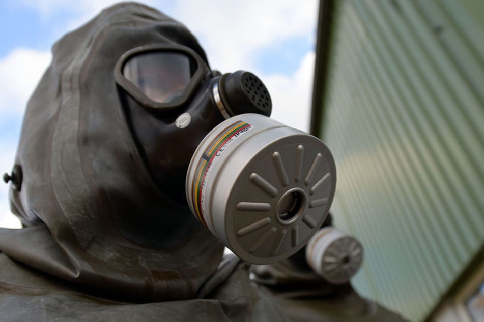 Den Stimmzettel in der Hand setzte sich der Mann eine Gasmaske auf.
