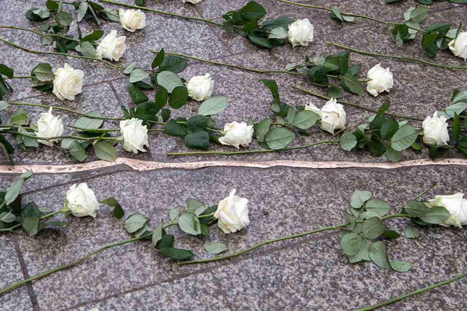 Weiße Rosen liegen bei der Einweihung der Gedenkstätte an der Gedächtniskirche auf den Boden.