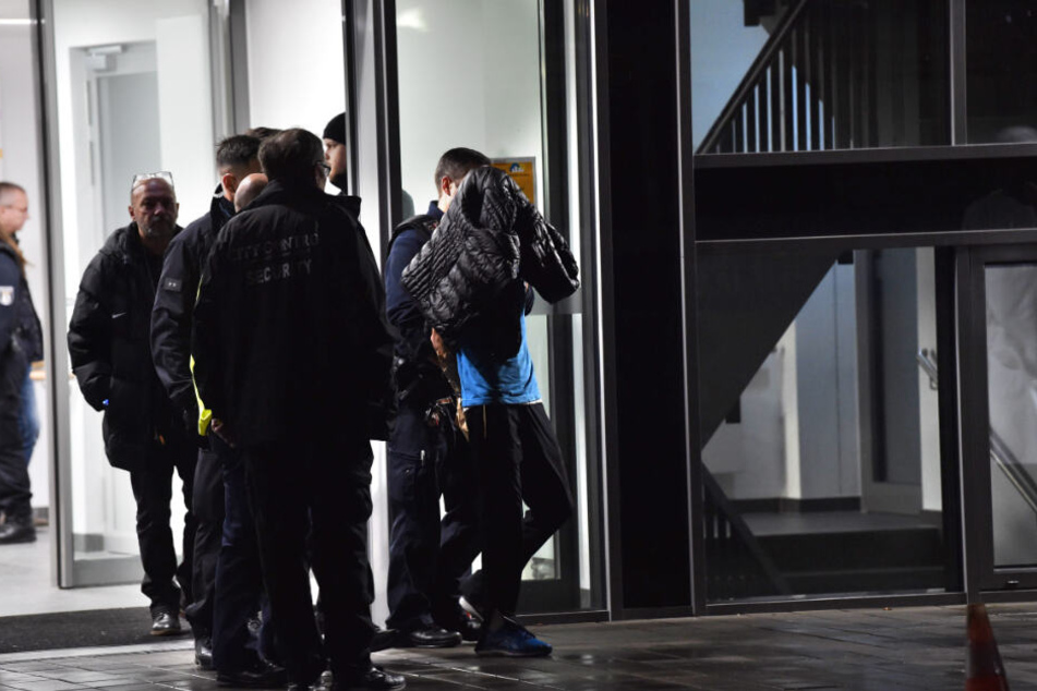 Polizisten nehmen nach der Messerattacke einen Mann fest.