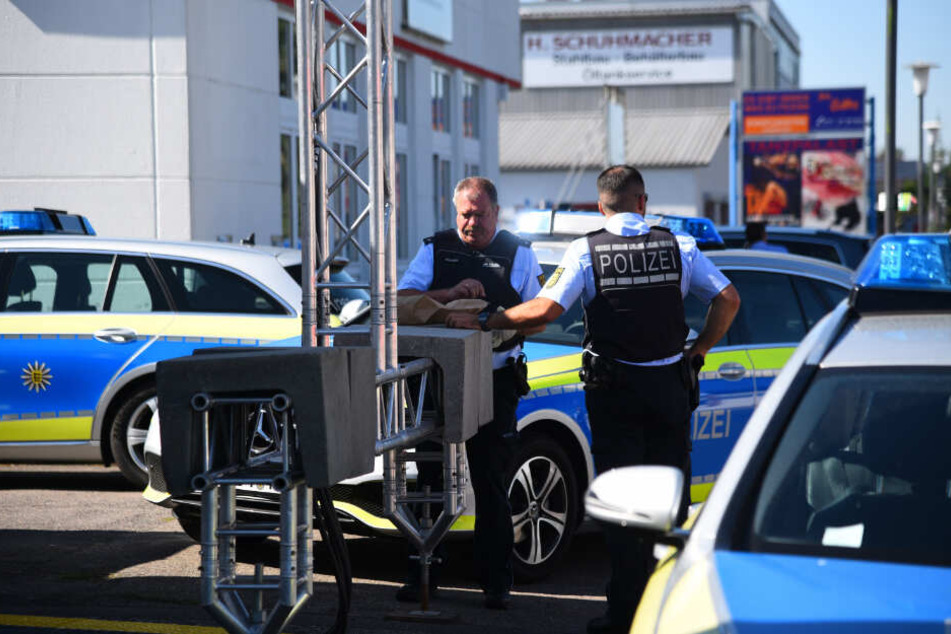 Mehrere Polizeiautos stehen um den Bereich der Tankstelle.