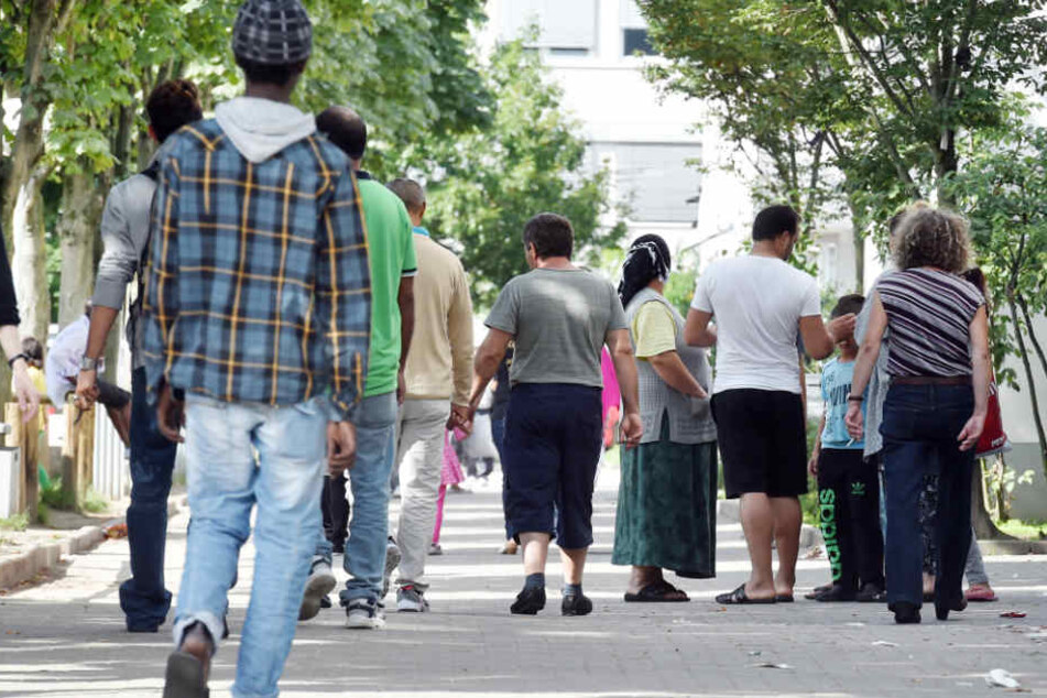 Flüchtlinge gehen vor der Landeserstaufnahme für Asylbewerber (LEA) in Karlsruhe.