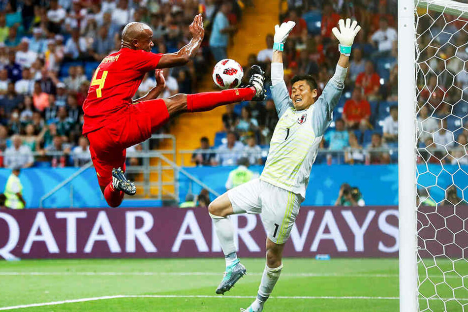 Über den Wolken: Vincent Kompany (l.) springt in ungeahnte Höhen und spielt den Ball noch in die Mitte, Japans Torhüter Eiji Kawashima (r.) kommt zu spät - doch kein Belgier belohnt Kompanys artistischen Einsatz, weshalb diese Chance verpufft.