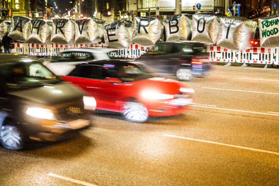 Mitglieder der Umwelt- und Naturschutzorganisation Robin Wood demonstrieren am Donnerstagabend an der B14 am Neckartor mit großen Folienwürfeln mit dem Schriftzug "Fahrverbot" gegen die Feinstaubbelastung in der Stadt und fordern die Reduzierung des Verke
