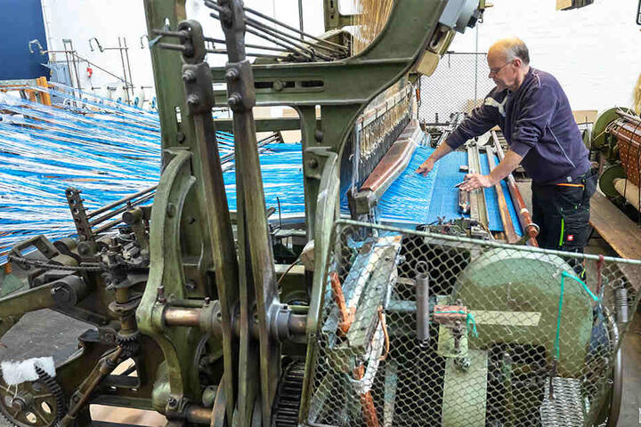 Webmeister Mario Thümer (56) verarbeitet die Spezialgarne an einem alten mechanischen Webstuhl, der robust genug für die starren Kunstgarne ist.