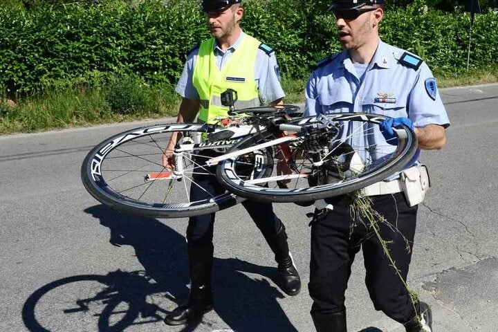 Die Polizeibeamten tragen das Fahrrad von Hayden weg.