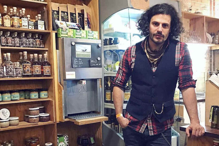 Schauspieler Manuel Cortez steht in seinem Hofladen vor dem Regal.