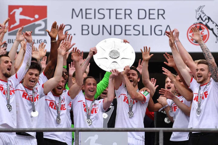 Die Spieler von Köln um Matthias Lehmann (Mitte links) und Jonas Hector (Mitte rechts) jubeln mit der Meisterschale der 2. Bundesliga.