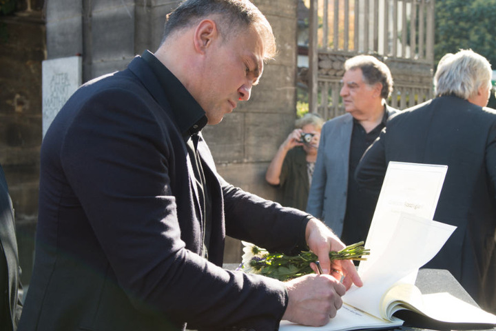 Der ehemalige Boxer Dariusz Michalczewski trägt sich in eine Kondolenzliste am Eingangstor zum Friedhof ein.