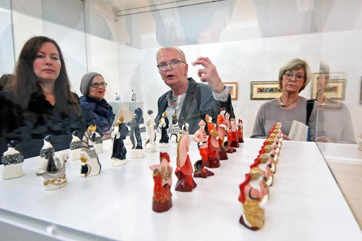 Kuratorin Katharina Metz vor einem Schaukasten mit Schachfiguren.