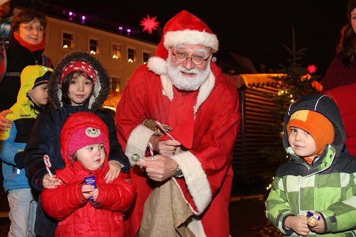 Sehnsüchtig warten die Kinder auf dem Weihnachtsmarkt in Pirna, dass der Weihnachtsmann Süßes verschenkt.