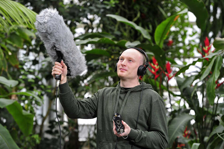 Der Doktorand fängt die Vogelstimmen mit einem Richtmikrofon ein.
