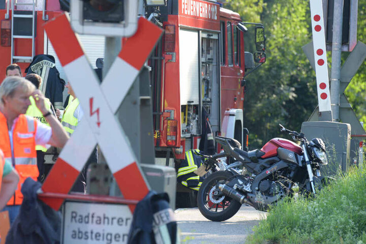 Ein verunglücktes Motorrad steht an einem Bahnübergang im bayerischen Harburg. Der Motorradfahrer wurde von einem Zug erfasst und tödlich verletzt.