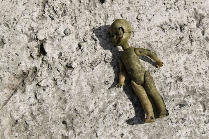 Eine kaputte Babypuppe liegt verlassen auf dem Boden (Symbolbild).