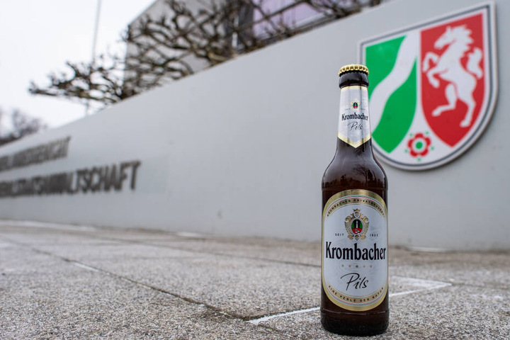 Eine Bierflasche von Krombacher vor dem Gericht.