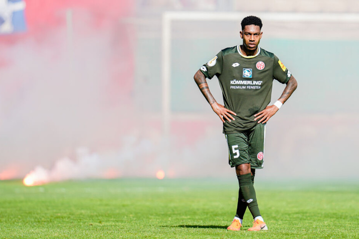 Jean-Paul Boetius von Mainz steht vor aufs Spielfeld geworfenen brennenden Bengalos.