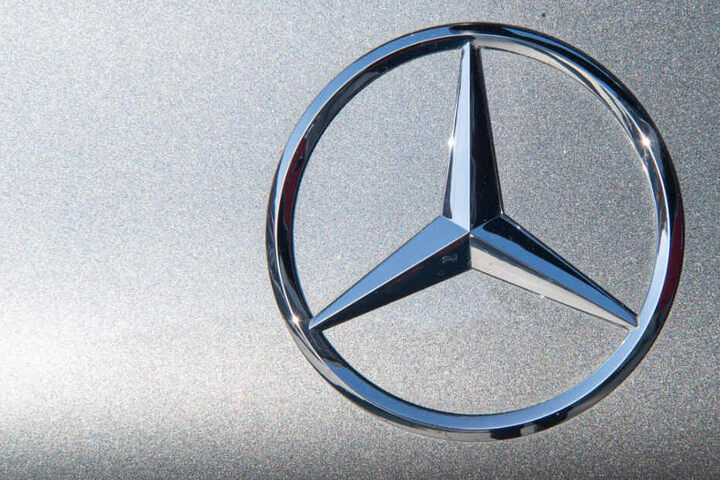 Die Sonne reflektiert sich in einem Mercedes-Stern.