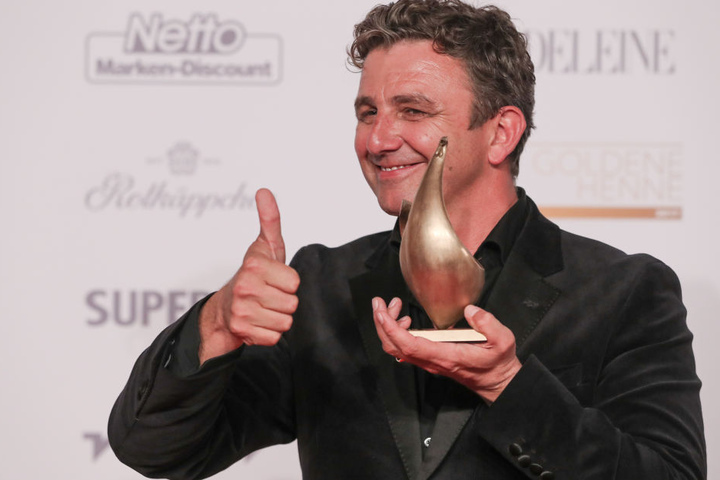 Der Schauspieler Hans Sigl posiert mit der Goldenen Henne, die er in der Kategorie "Schauspiel" erhalten hat.