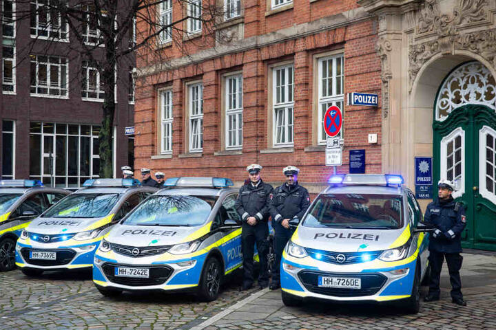Polizisten präsentieren die neuen Streifenwagen.