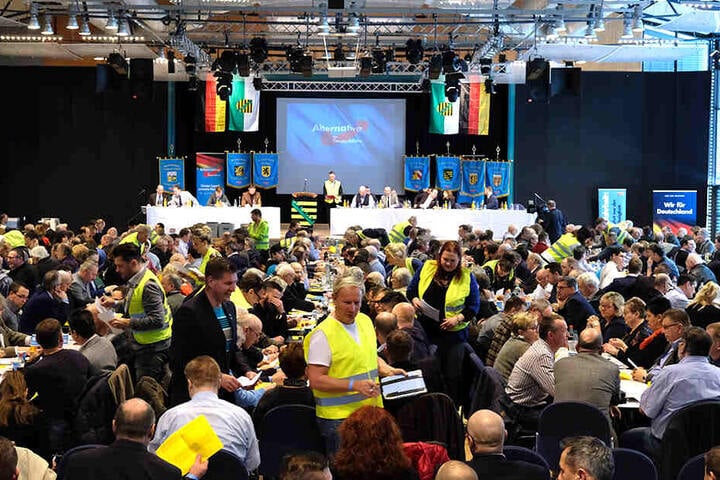 Vollbesetzter AfD-Parteitag. Mitglieder der Zählkommission tragen Gelbwesten.