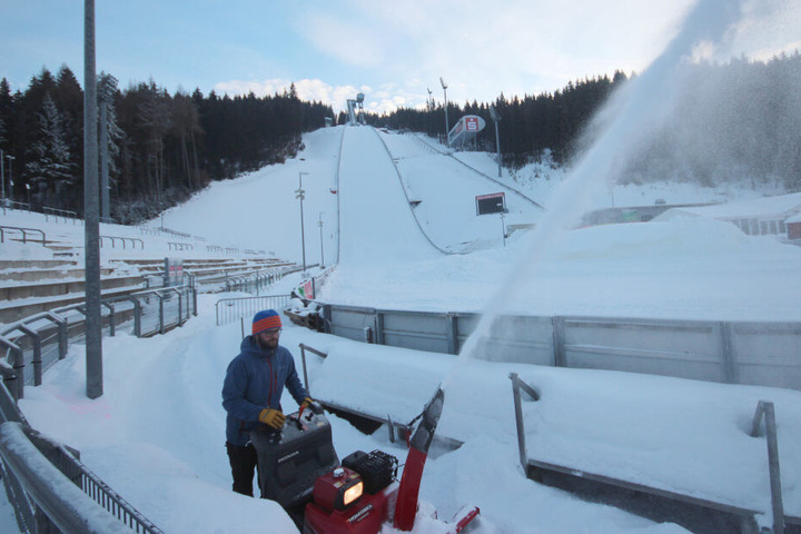 Marcus Stark vom VSC ist mit der Schneefräse unterwegs, um die Zuschauertraversen von der weißen Last zu befreien.
