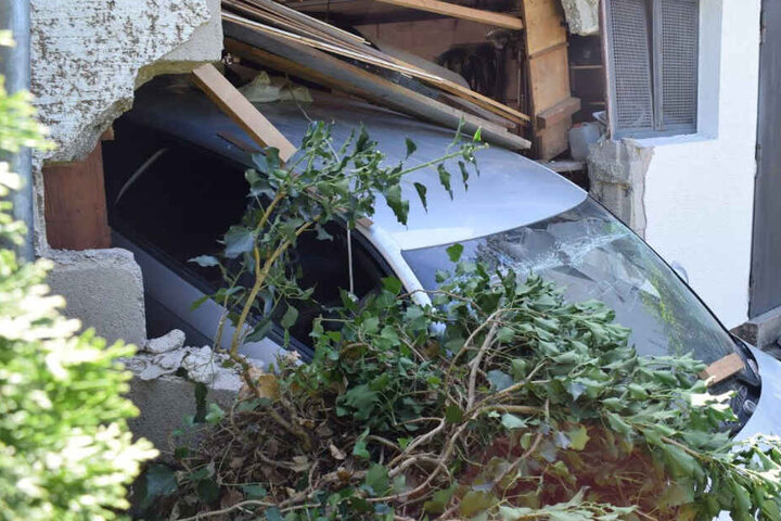Die Frau durchbrach mit ihrem Auto die Garagenwand und blieb an der Mauer stecken.