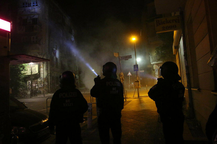 Die Polizisten versuchen, mit Taschenlampen die Steinewerfer ausfindig zu machen.