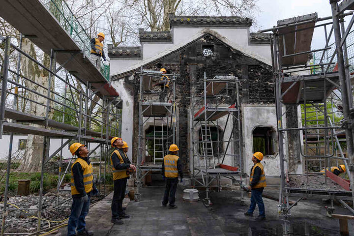 Spezialisten aus China bauen den Pavillon wieder auf.