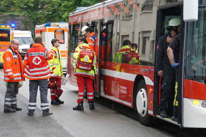 Rettungskräfte vor einem Bus der Feuerwehr.