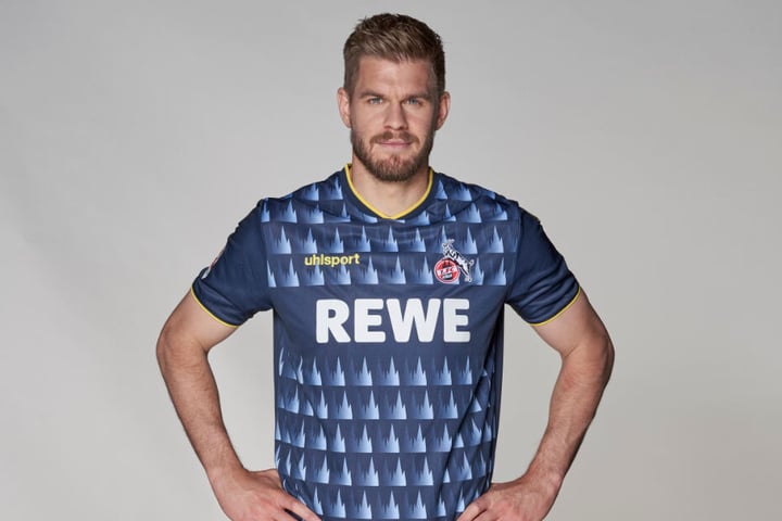 Simon Terrodde zeigt das neue Ausweichtrikot des 1. FC Köln. Es hat Dom-Symbole aufgedruckt.