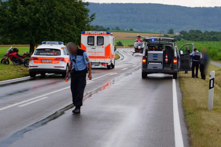 Ein Polizist geht über die nasse Fahrbahn.