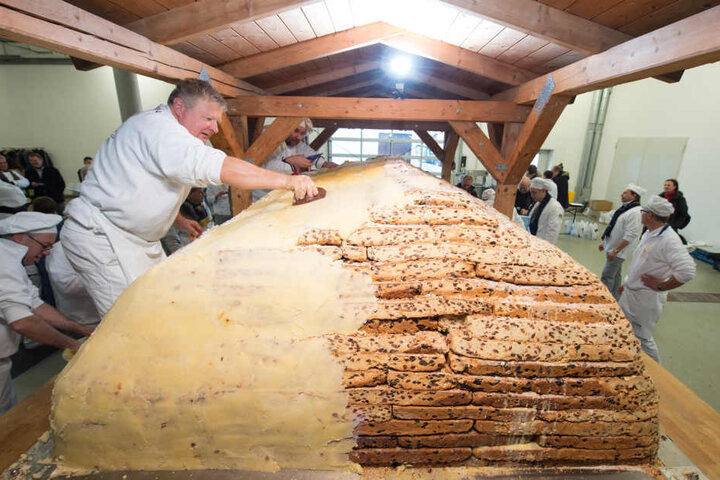 Bäckermeister Thomas Schmidt bestreicht den Riesenstollen mit Butter und Zucker. Mittlerweile ist das Naschwerk fertig, wird Samstag präsentiert.