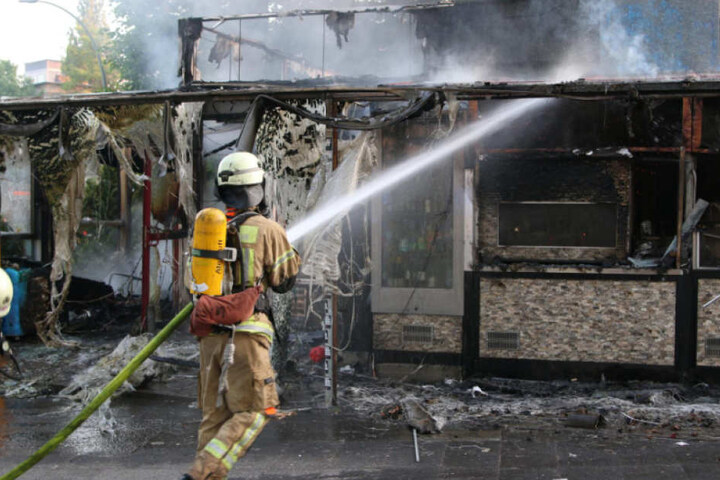 Ein Berliner Feuerwehrmann löscht die letzten Flammen.