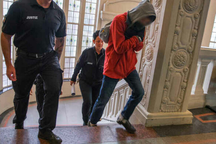 Der Angeklagte wird zum Prozessbeginn um den Mord an einem Rentner in Wittenburg zum Gerichtssaal geführt.
