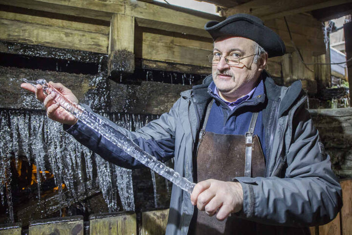 Bernd Schreiter (54, Museumsführer Frohnauer Hammer) mit den Eiszapfen am Wasserrad.