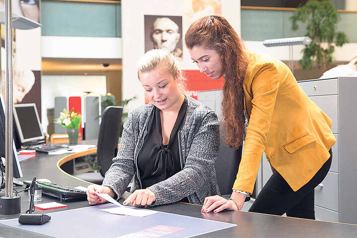 Cindy (21) lässt sich von Serviceberaterin Lisa Fröde (25) erklären, worauf sie bei Überweisungen achten muss.