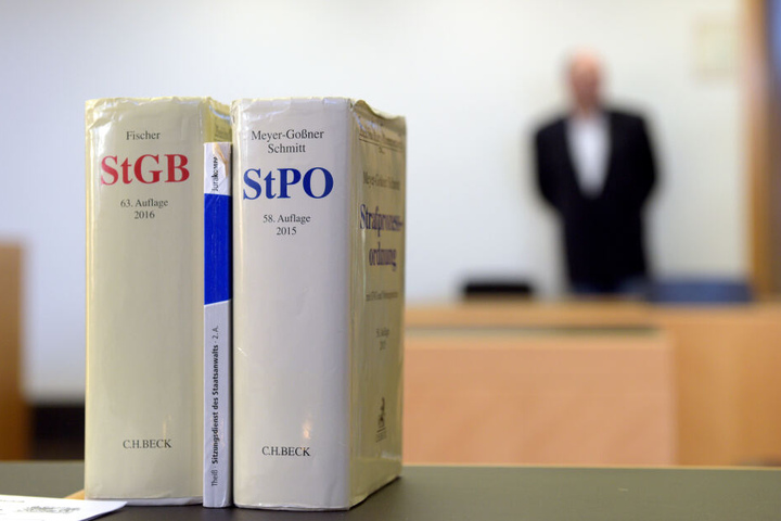 Ein Sitzungssaal im Amtsgericht in Augsburg, im Vordergrund zwei Bände der Strafprozessordnung.