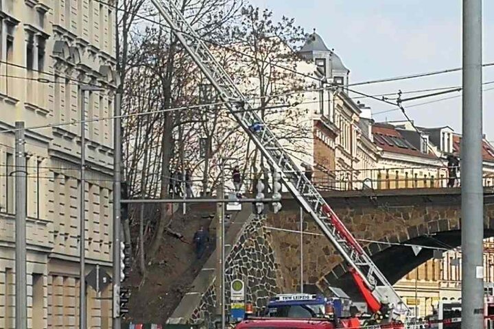 Polizisten bitten Schaulustige, von der Brücke zu gehen.