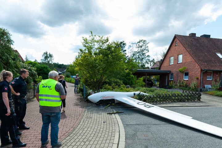 Das abgestürzte Segelflugzeug liegt in einem Vorgarten.