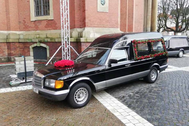 Der geschmückte Leichenwagen steht vor dem Michel.